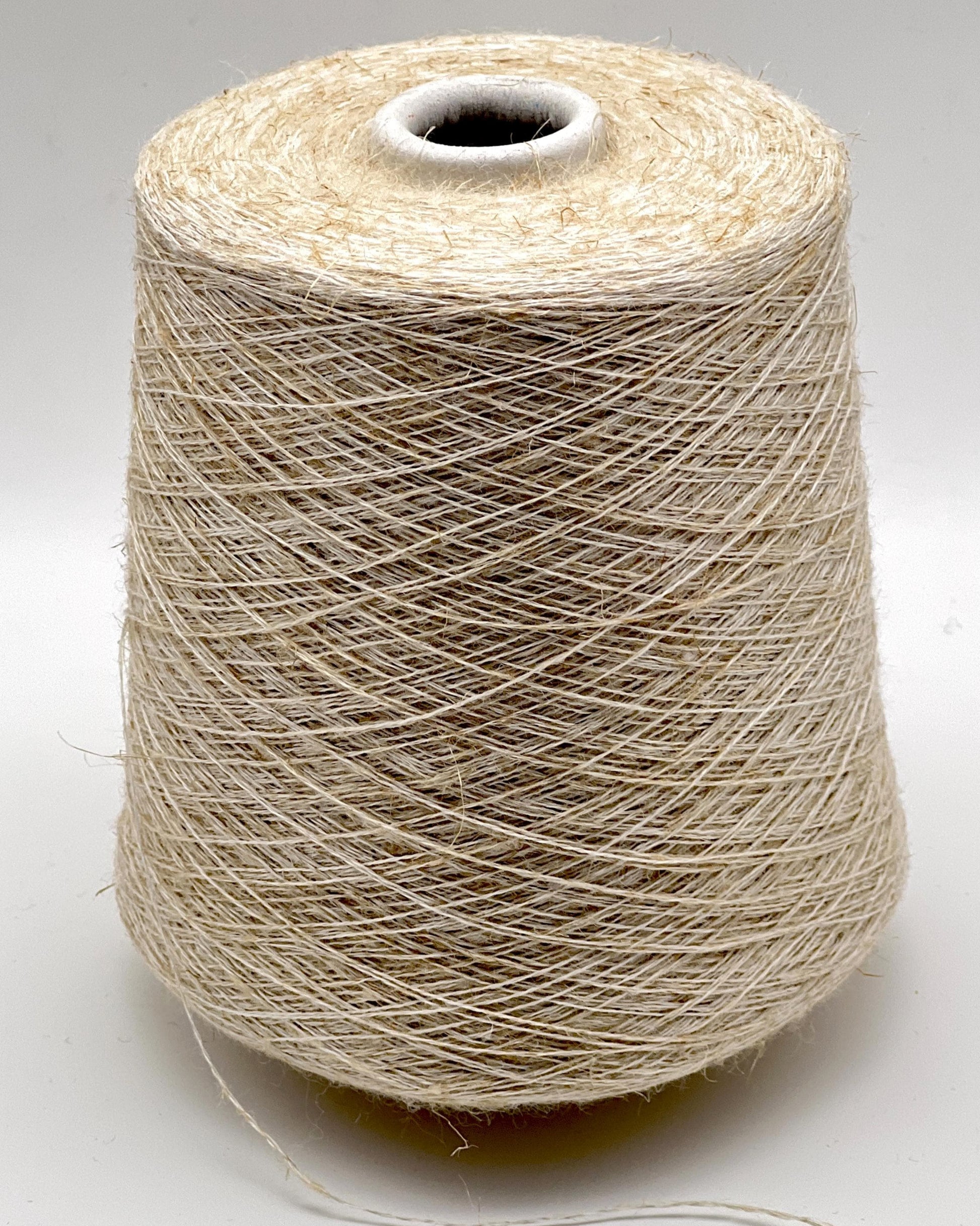 Spool of beige thread on a white background