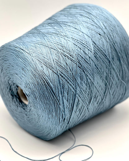 Close-up of a blue spool of yarn on a white background