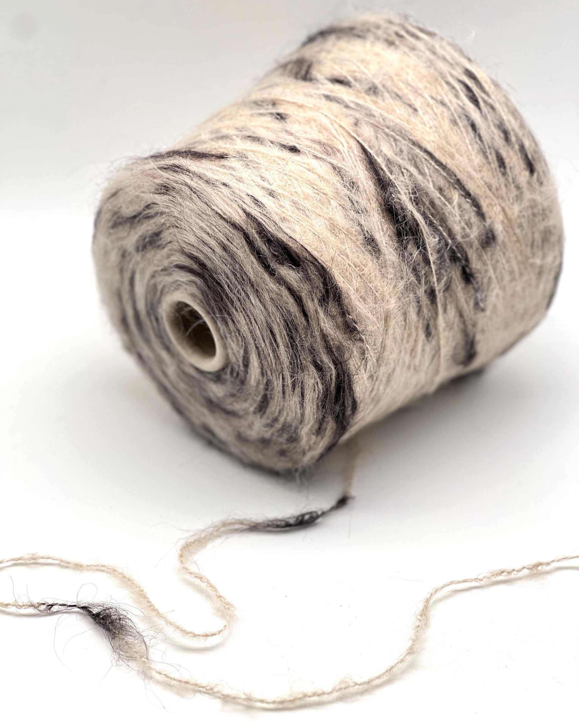 Spool of yarn with a marbled pattern on a white background