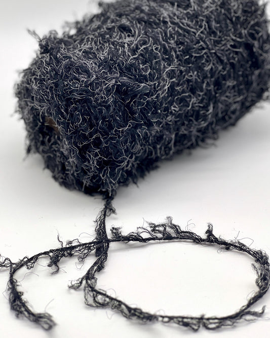 Luxury fluffy fur merino silk yarn WISH GLOW Italy
black furry chunky yarn with grey fibers designer texture
Italian fluffy statement yarn for sweaters jackets and scarves
dramatic fur effect merino silk yarn close up texture
couture style fluffy winter yarn cone Italy