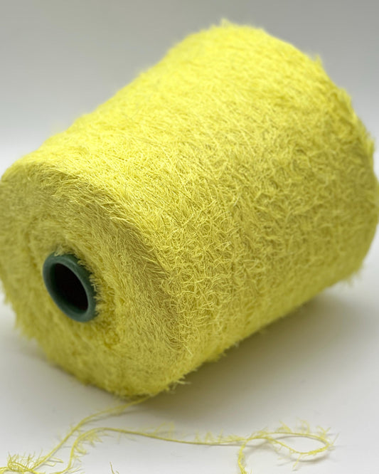 Roll of yellow yarn on a white background