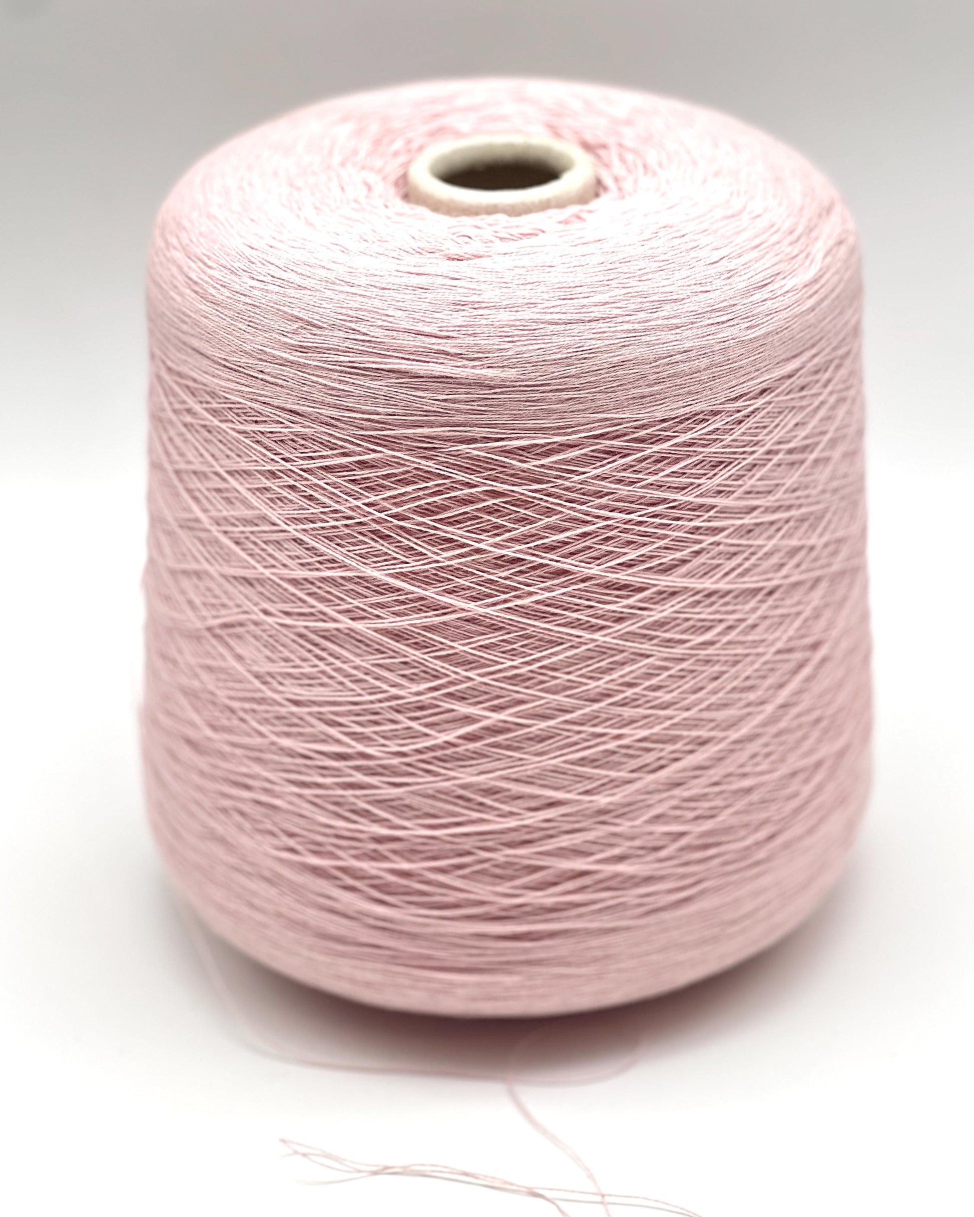 Pink spool of yarn on a white background