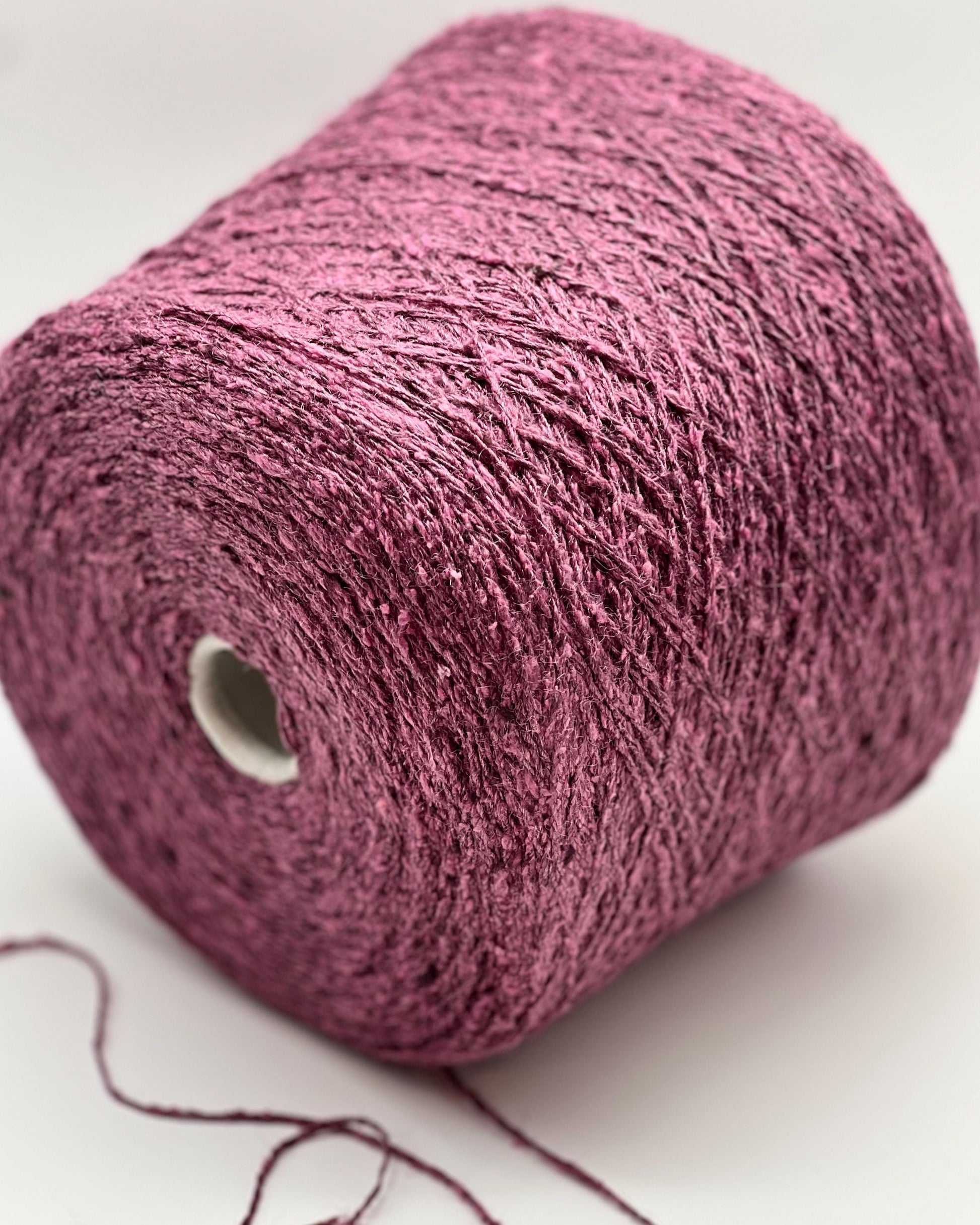 Close-up of a pink skein of yarn on a white background