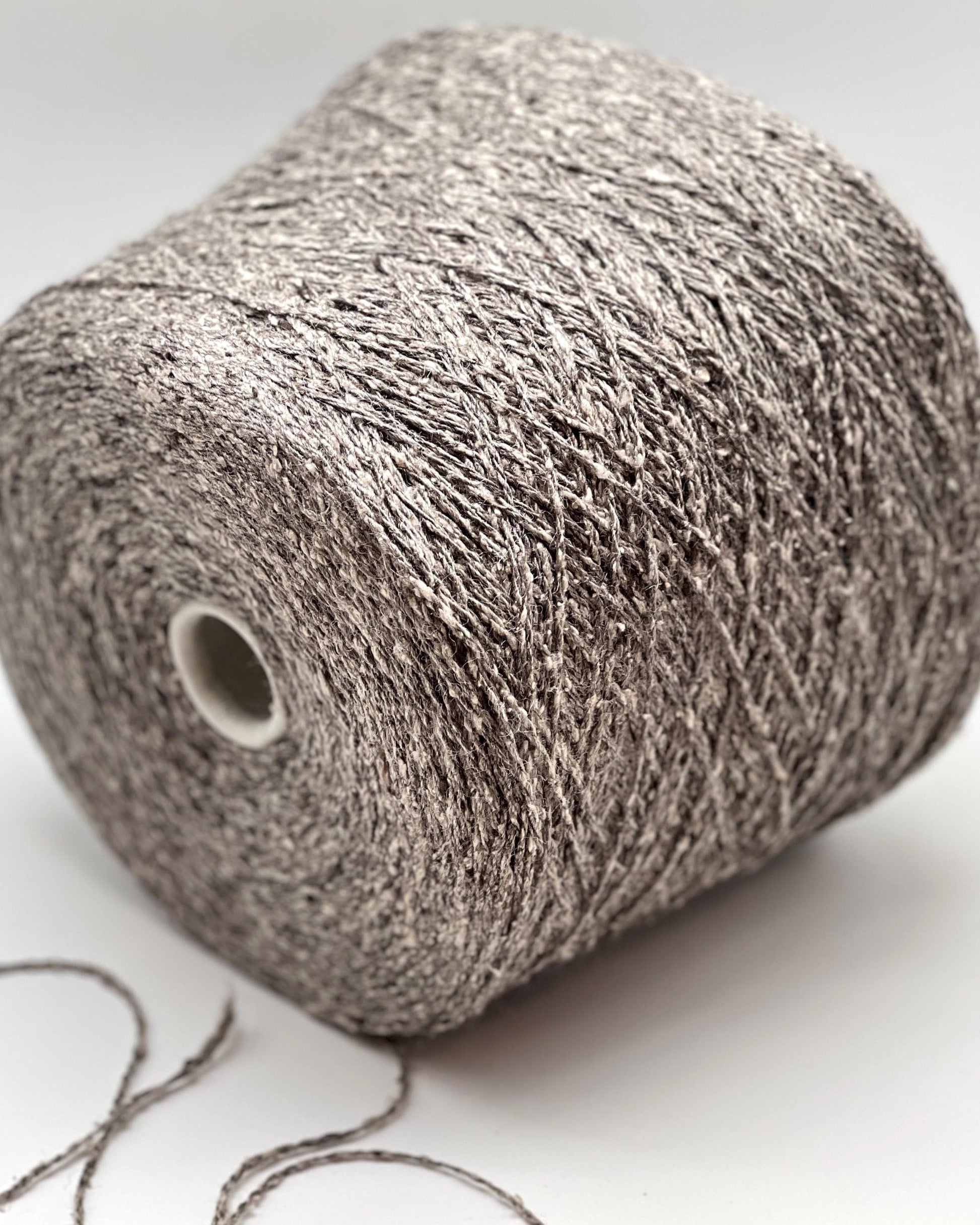 Spool of gray yarn on a white background