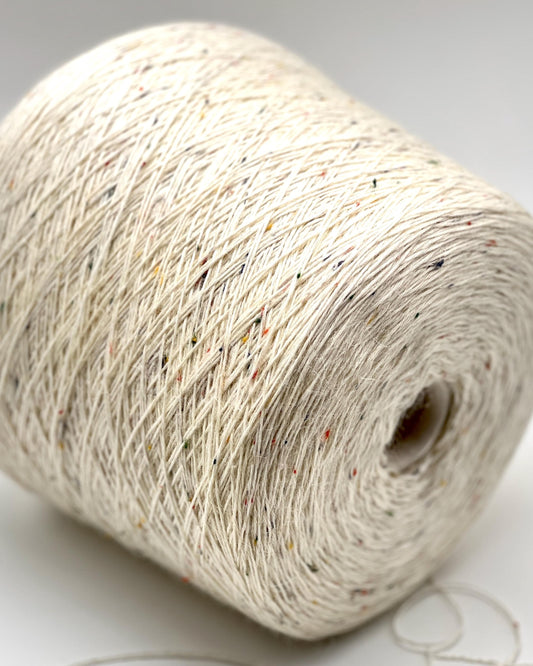 Close-up of a roll of beige yarn on a light background