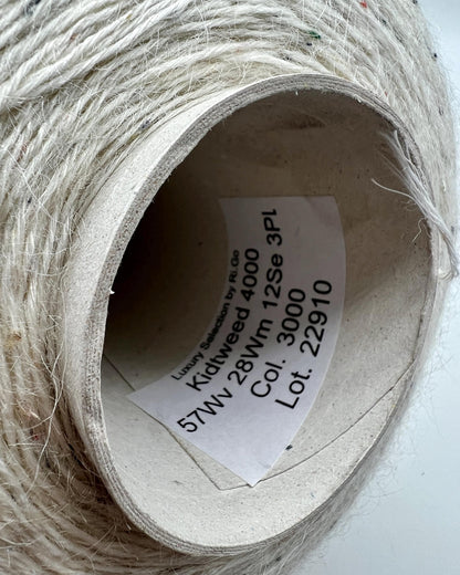 Spool of white thread with a label inside on a white background