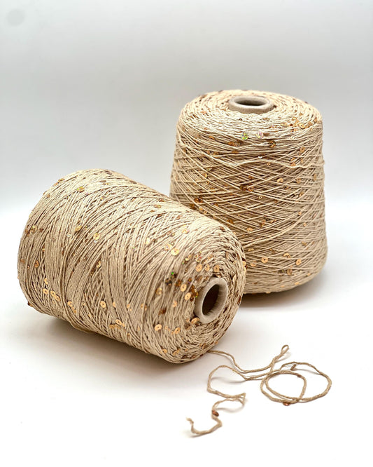 Two spools of beige thread on a white background
