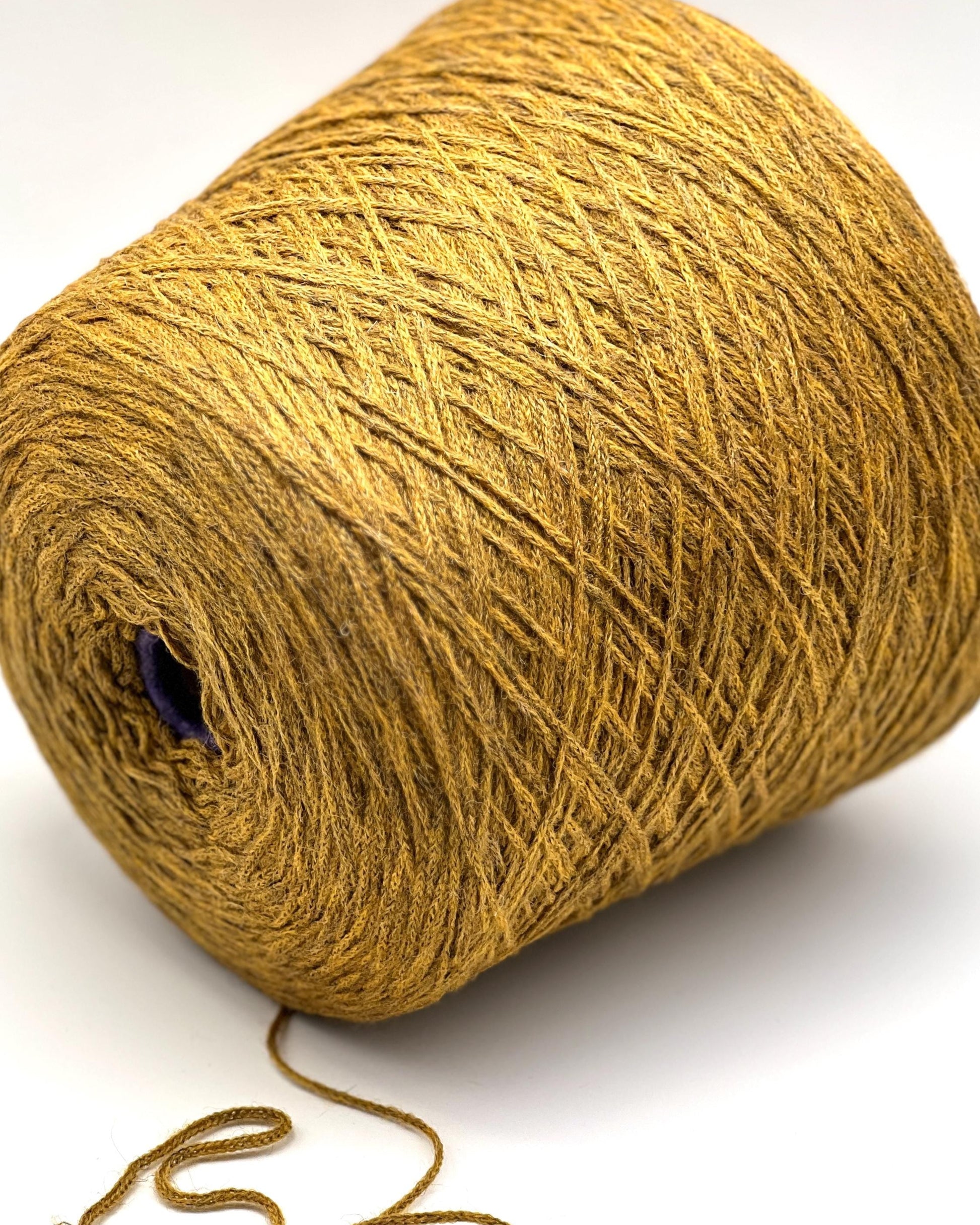 Large ball of gold yarn on a white background