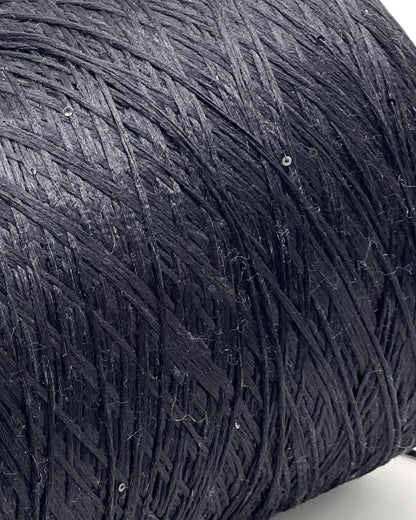 Close-up of a textured black fabric with sequins on a white background