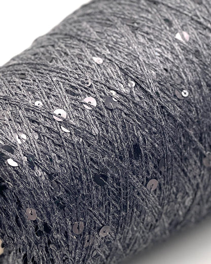 Close-up of a roll of dark gray fabric with sequins on a white background