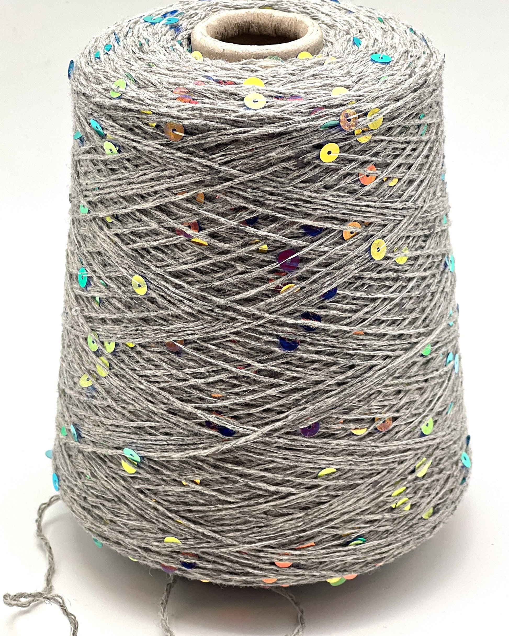 Spool of gray yarn with colorful specks on a white background