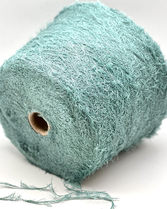 Roll of teal string on a white background