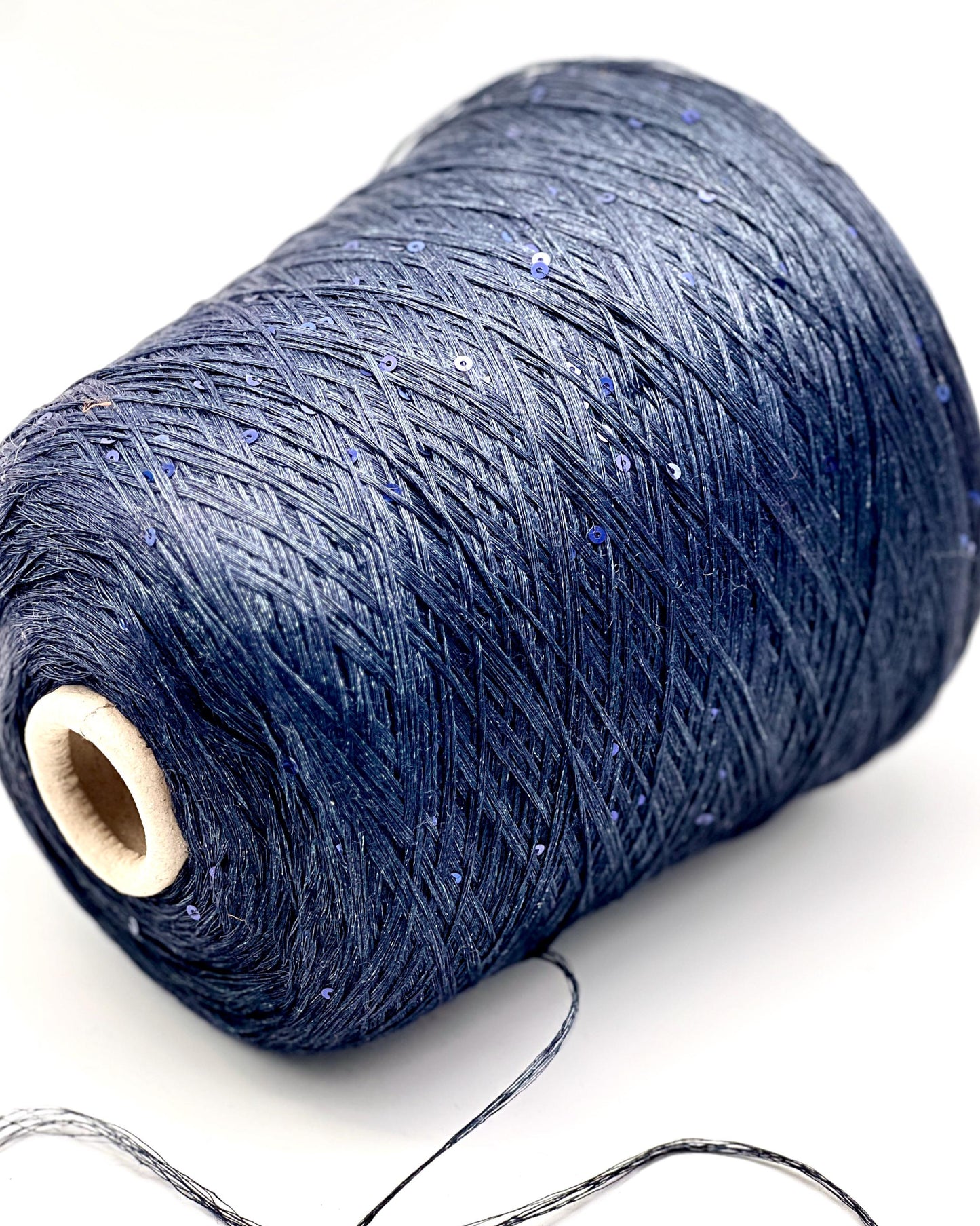 Spool of dark blue thread on a white background