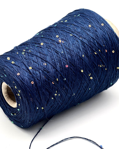 Roll of blue thread with sequins on a white background