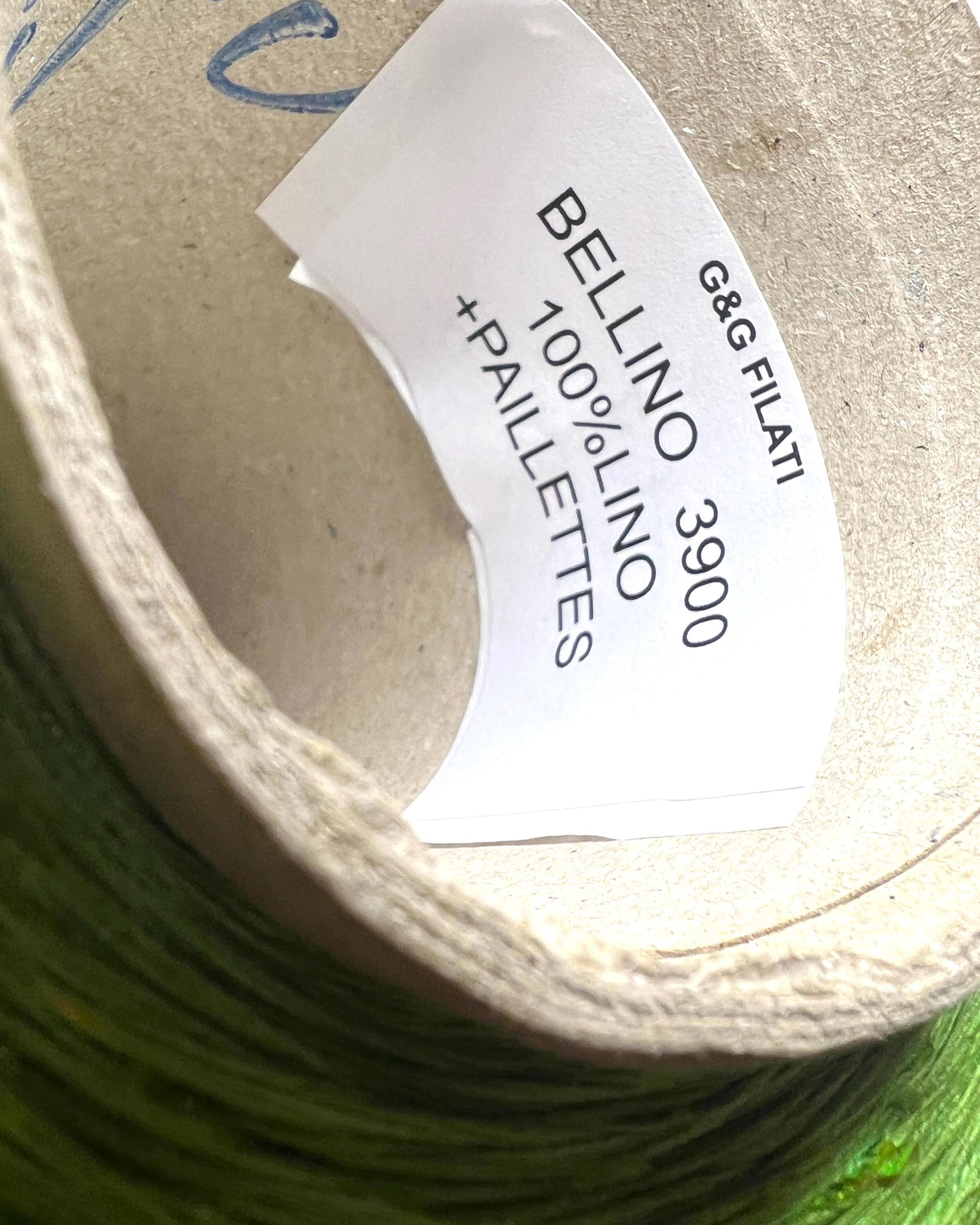 Spool of green thread with a label on a green background