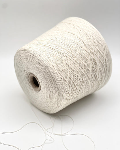 Large spool of white yarn on a light gray background