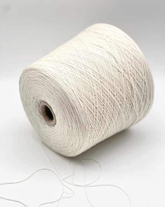 Large spool of white yarn on a light gray background