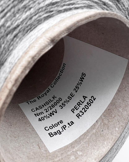 Close-up of a spool of yarn with a label on a white background
