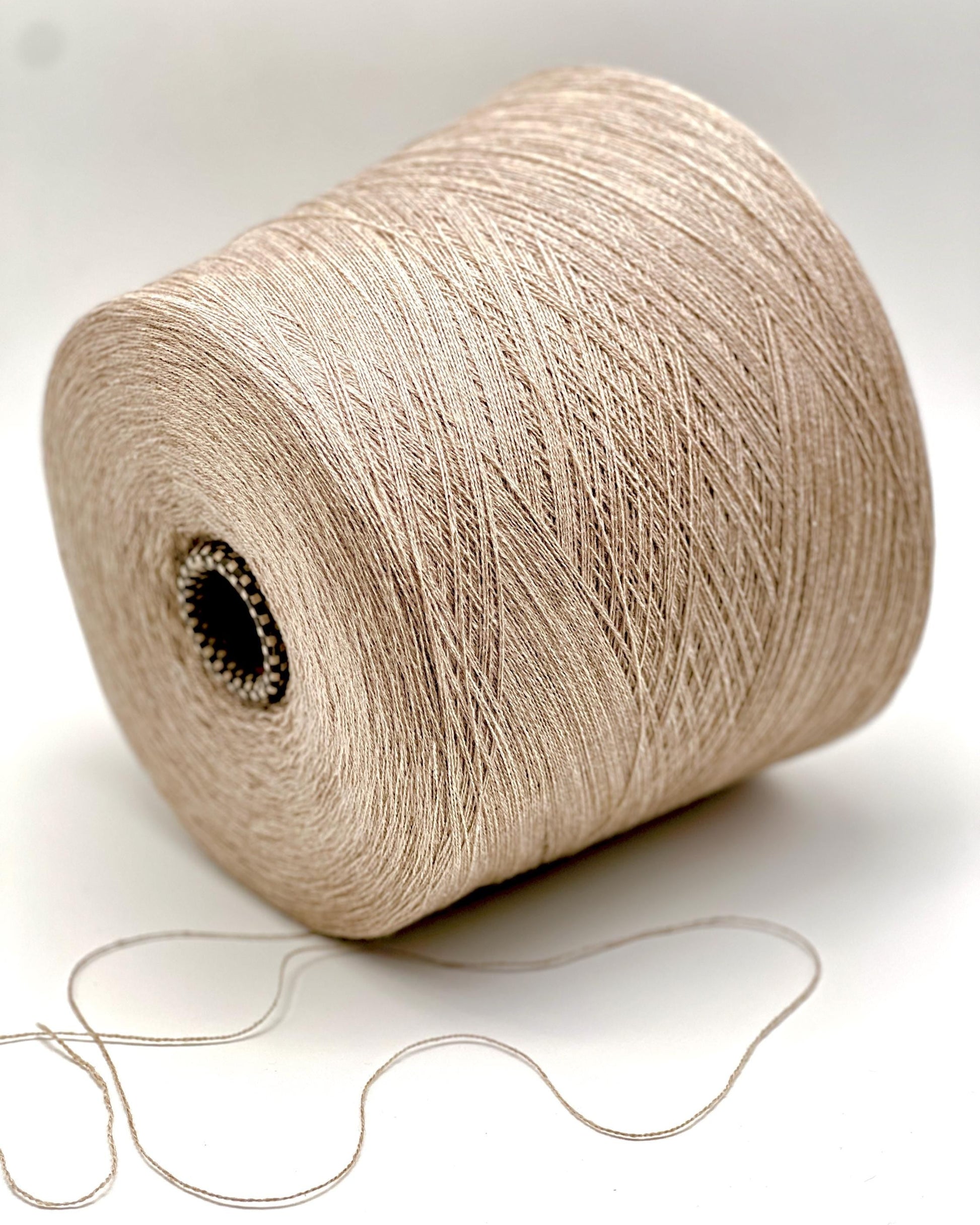 Spool of beige yarn on a white background