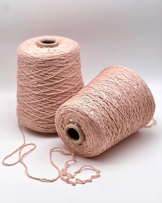 Two pink skeins of yarn on a white background