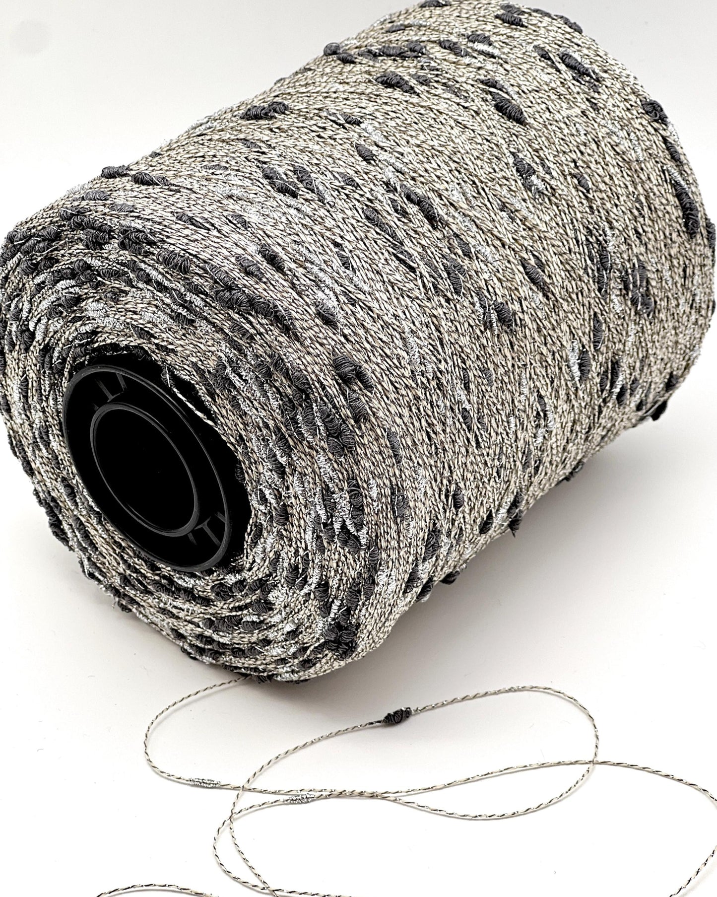 Roll of gray yarn with a black core on a white background
