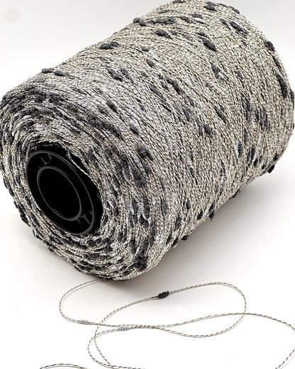 Roll of gray yarn with a black core on a white background