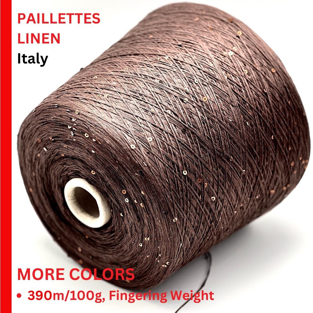 Spool of brown linen yarn with glittery accents on a white background
