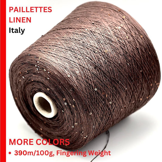 Spool of brown linen yarn with glittery accents on a white background