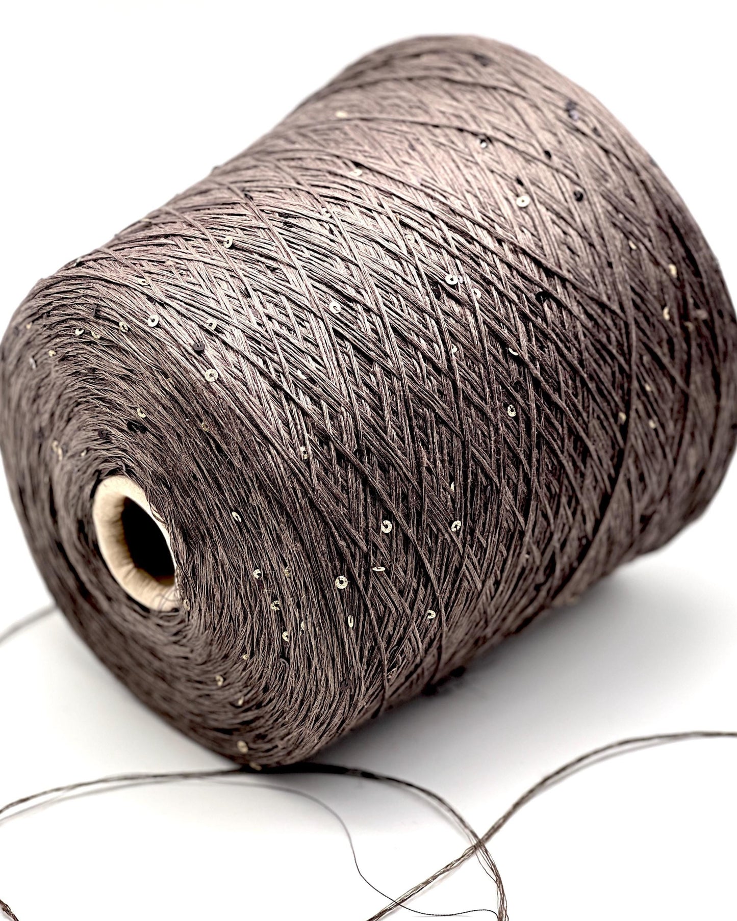Spool of brown thread on a white background