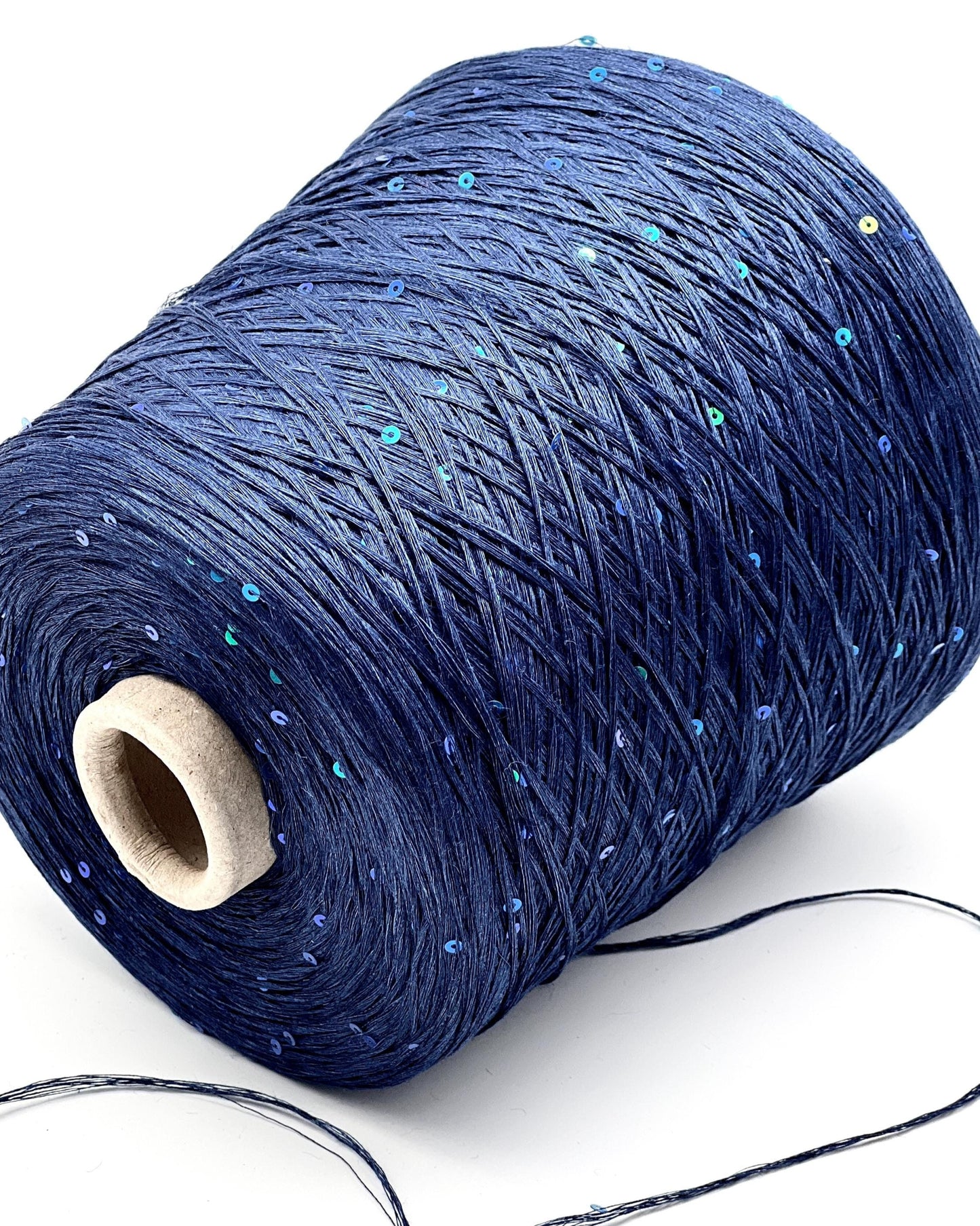 Spool of blue yarn with a wooden core on a white background