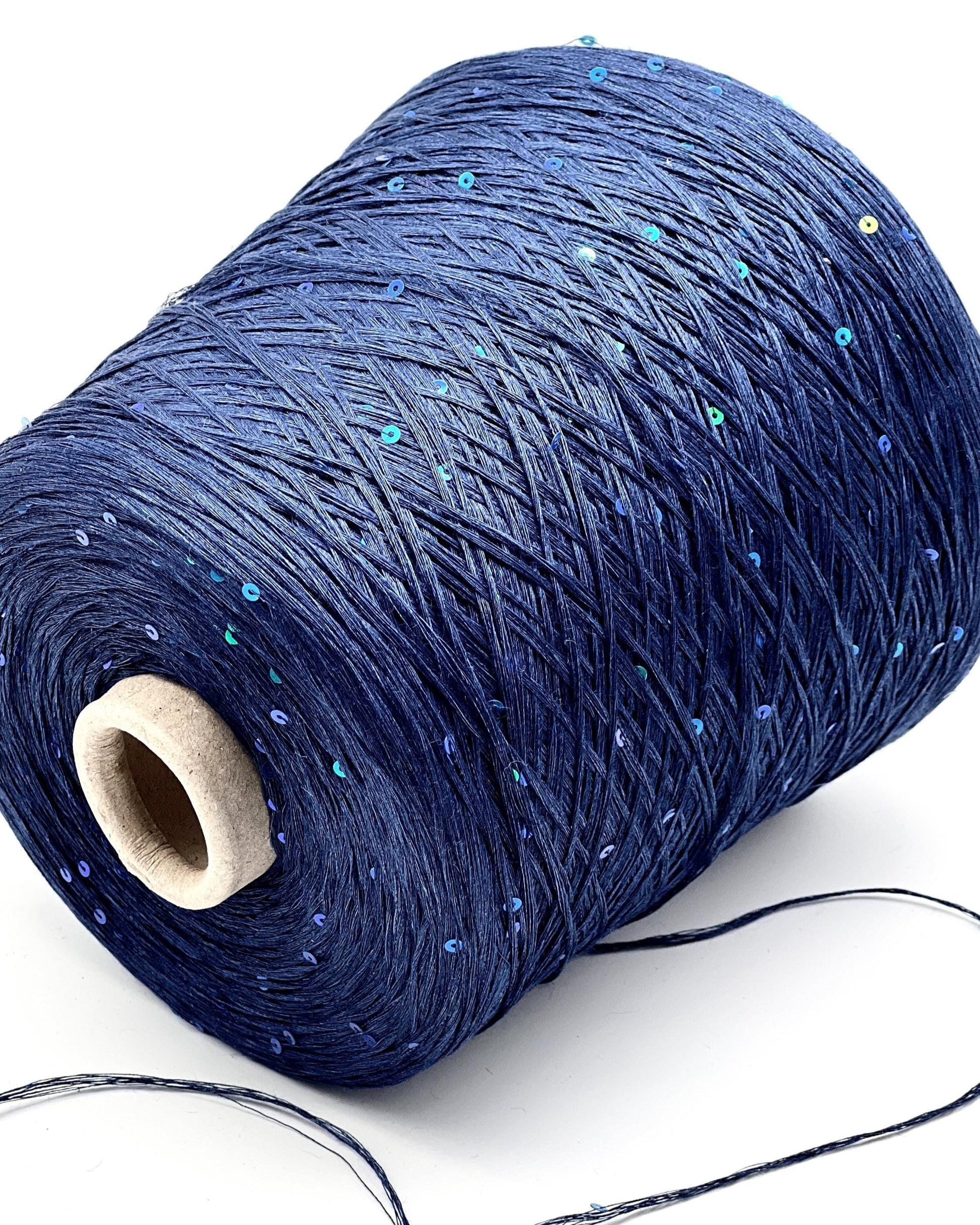 Spool of blue yarn with a wooden core on a white background