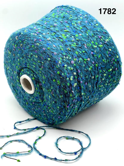 COLOR 1782 AQUA MULTI - Spool of blue yarn with speckles on a white background