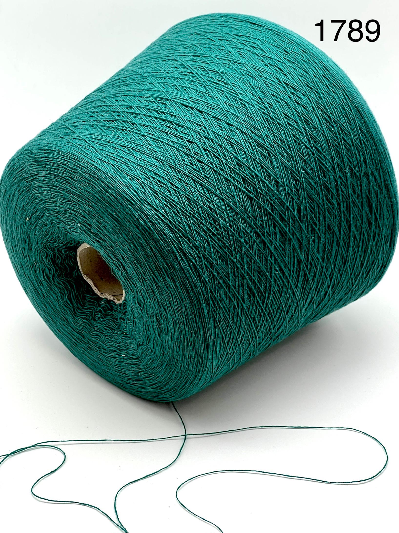 Teal spool of yarn with a small amount of yarn extending on a white background