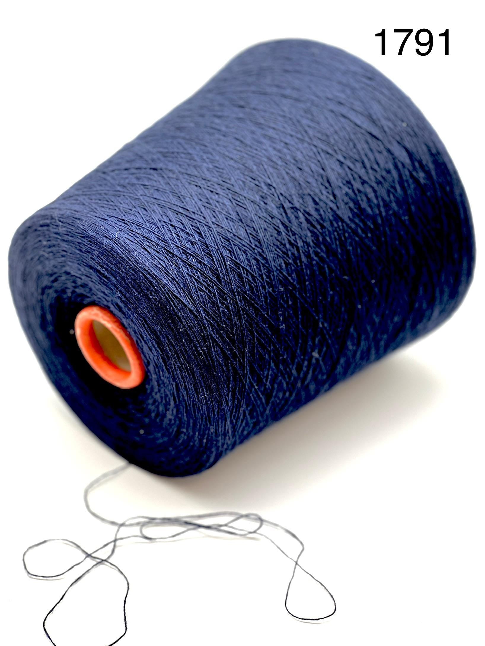 Spool of dark blue thread with a small amount of thread unwound on a white background