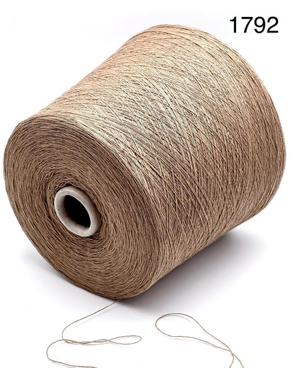 Spool of beige yarn with a needle on a white background