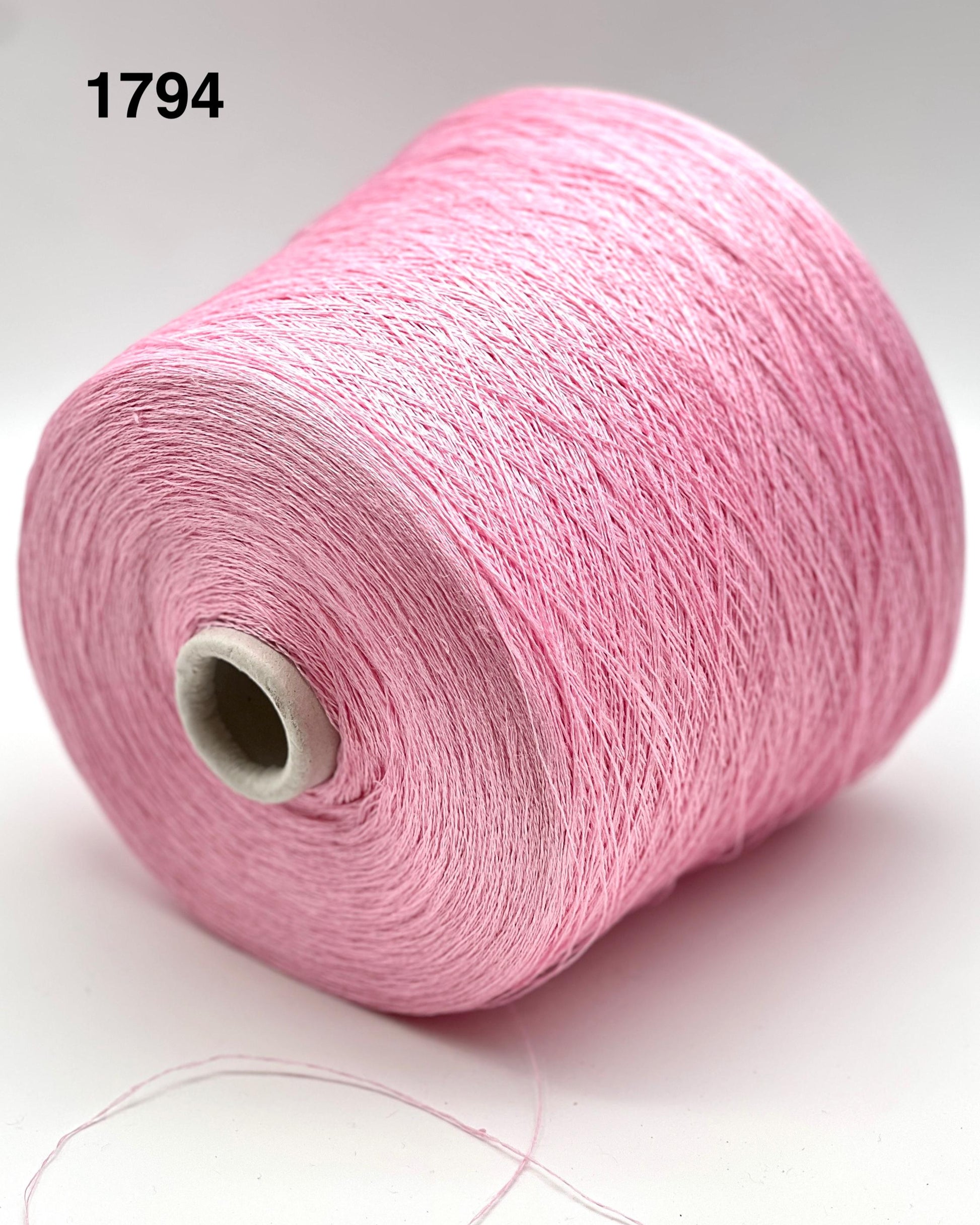 Pink spool of yarn on a white background