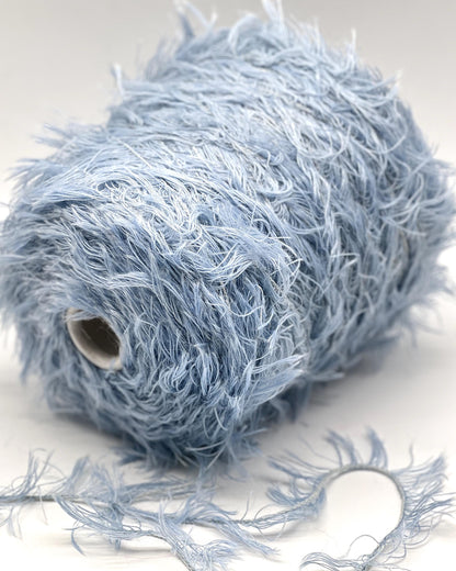 Blue yarn ball with loose strands on a white background