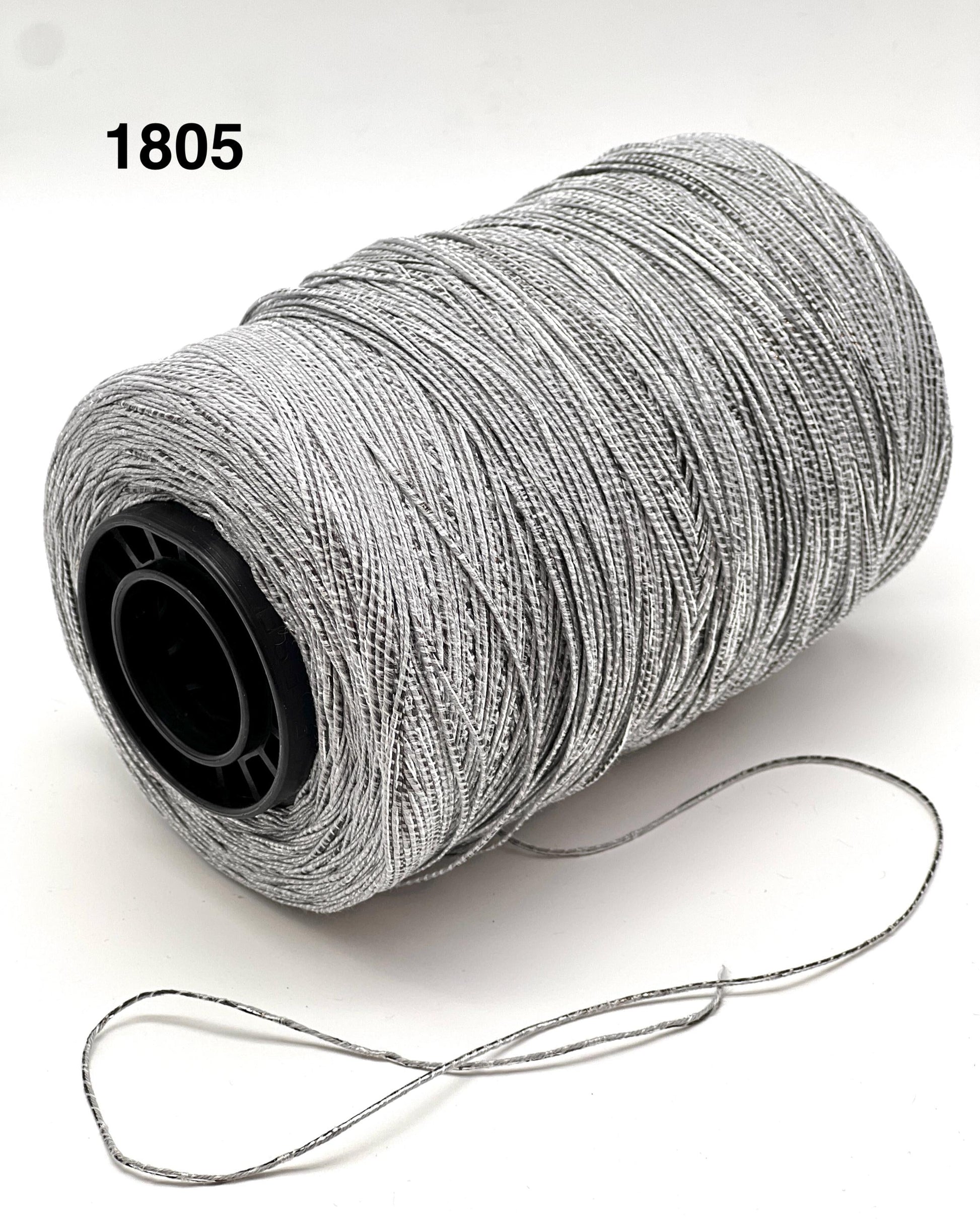 Spool of gray thread with a black core on a white background