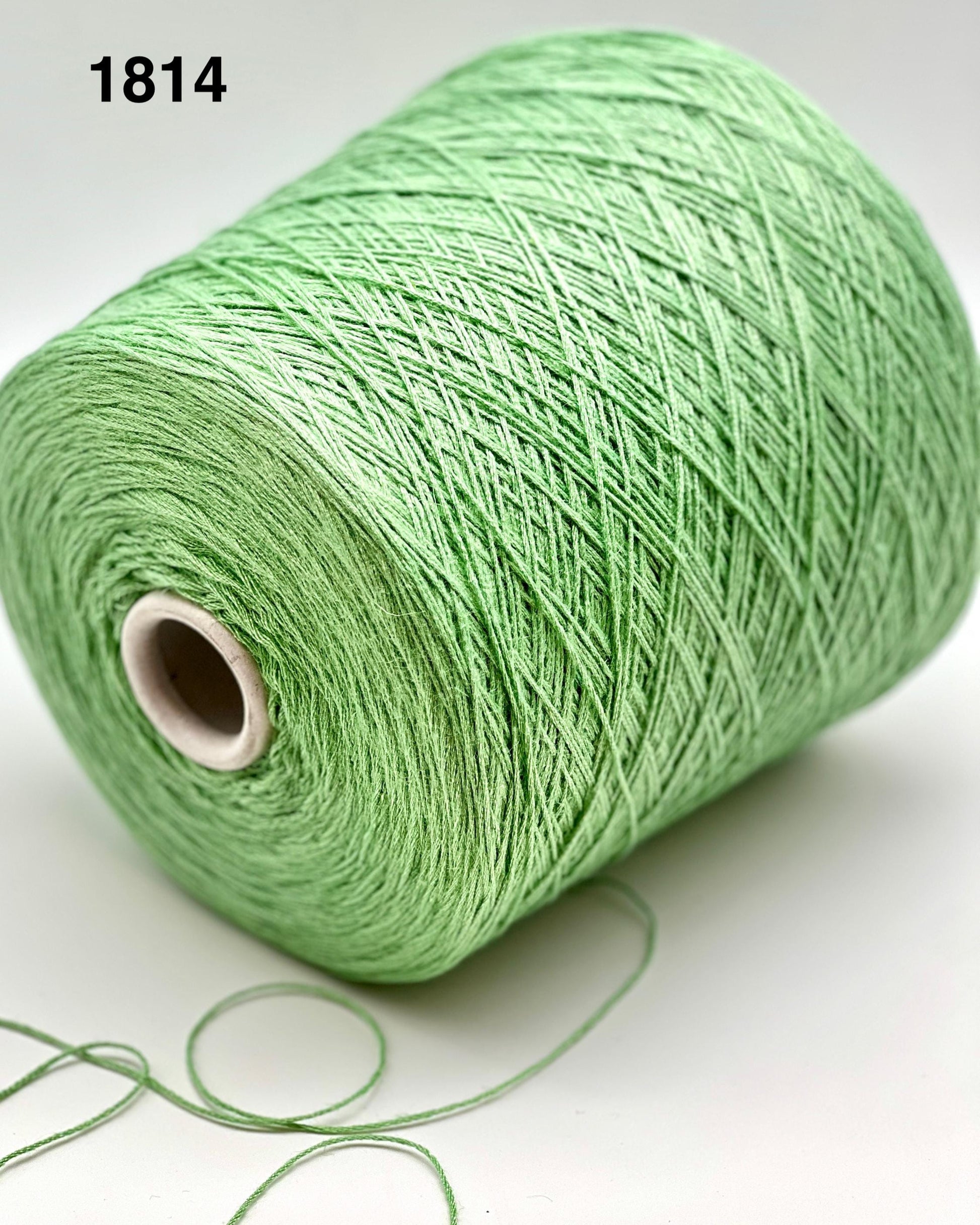 Green spool of yarn on a white background