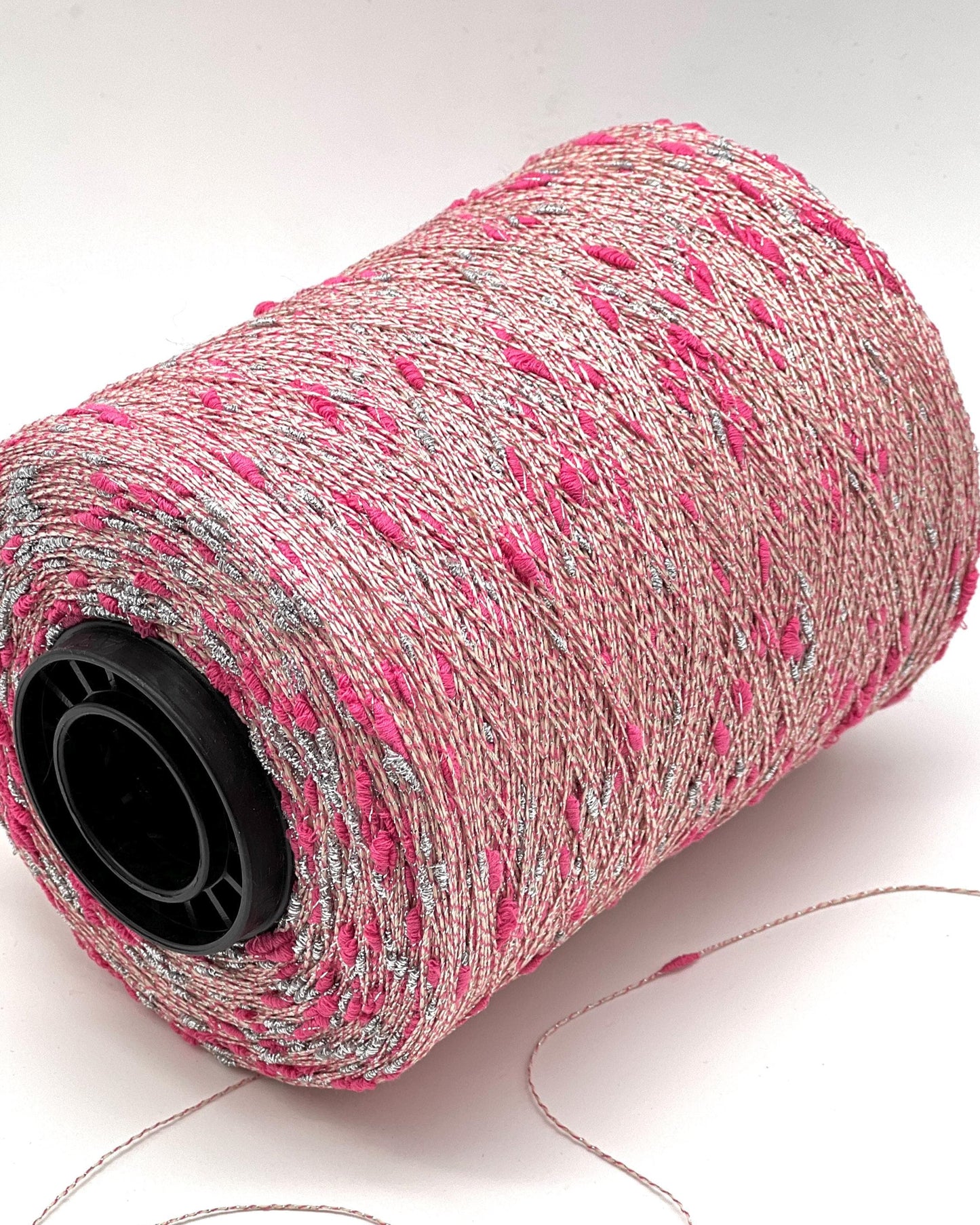 Spool of pink and gray thread on a white background