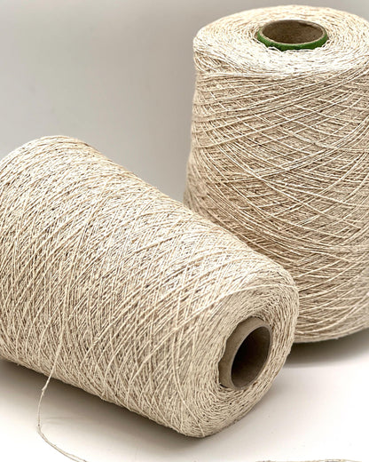 Two spools of beige thread on a light gray background