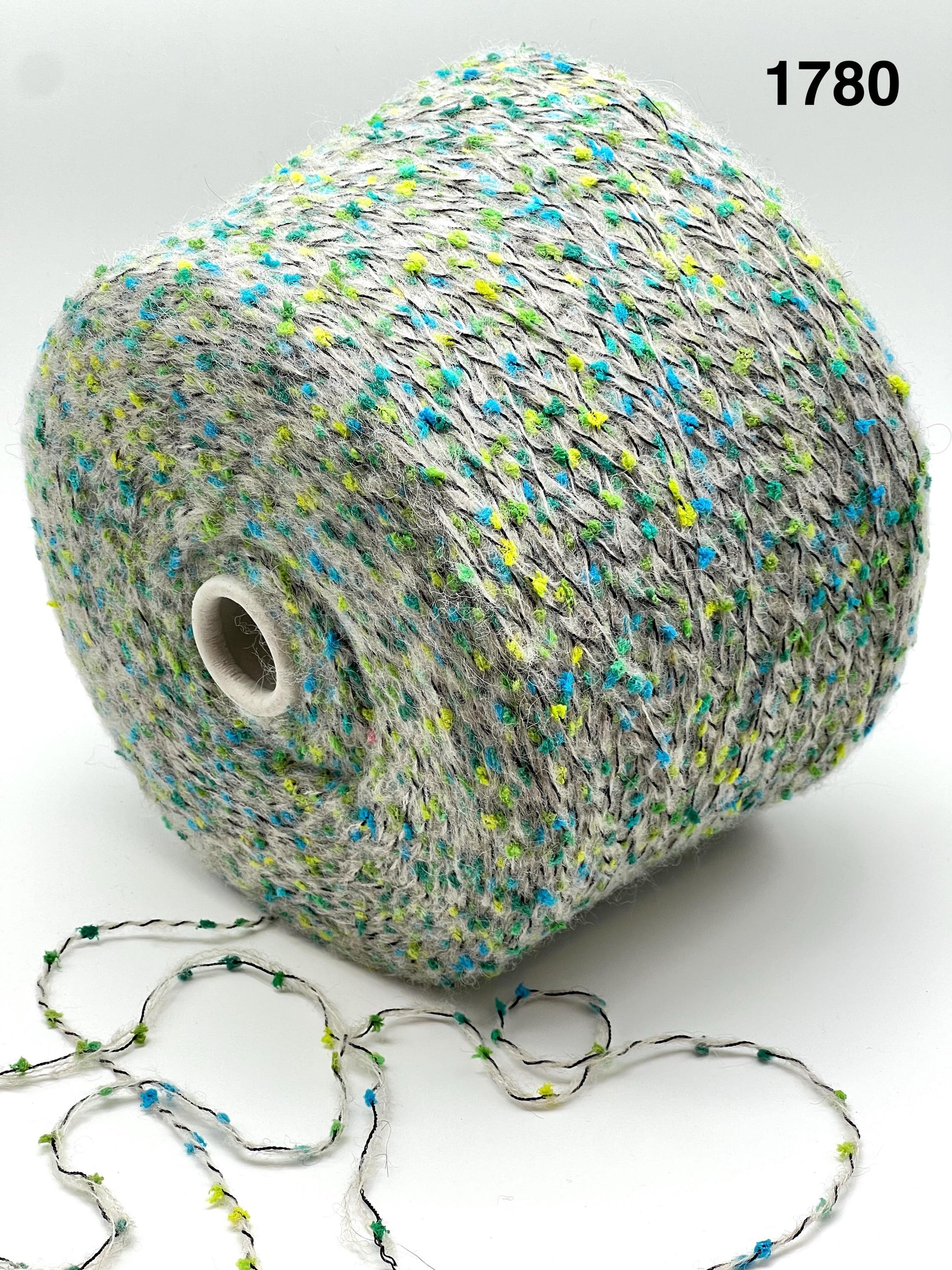 COLOR - 1780 GREY MULTI - Spool of multicolored yarn with a string of yarn loops on a white background