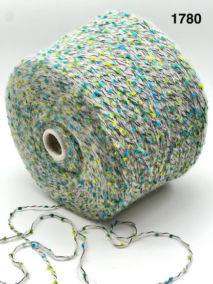 COLOR - 1780 GREY MULTI - Spool of multicolored yarn with a string of yarn loops on a white background