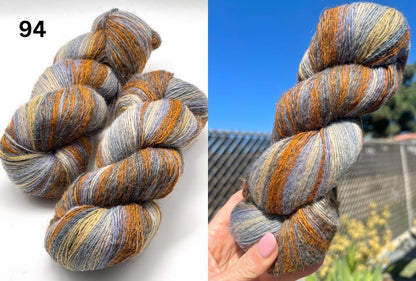 Multicolored skein of yarn on a white background with a close-up of a hand holding the yarn.