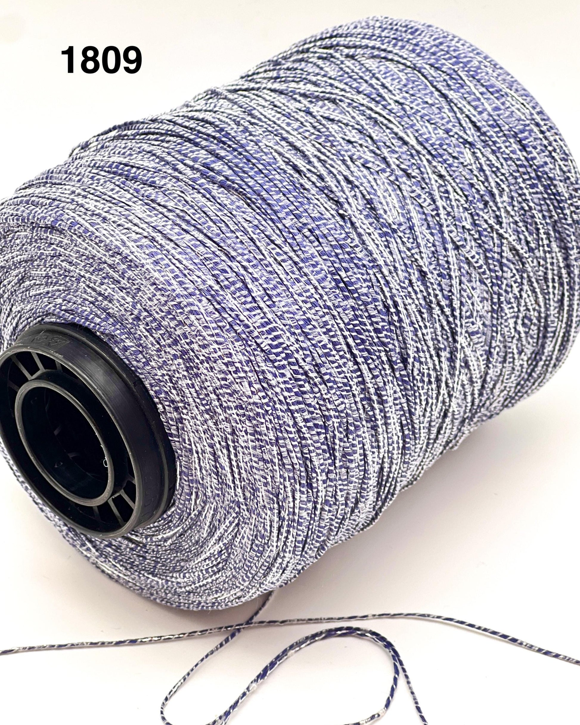 Spool of gray thread with a black core on a white background