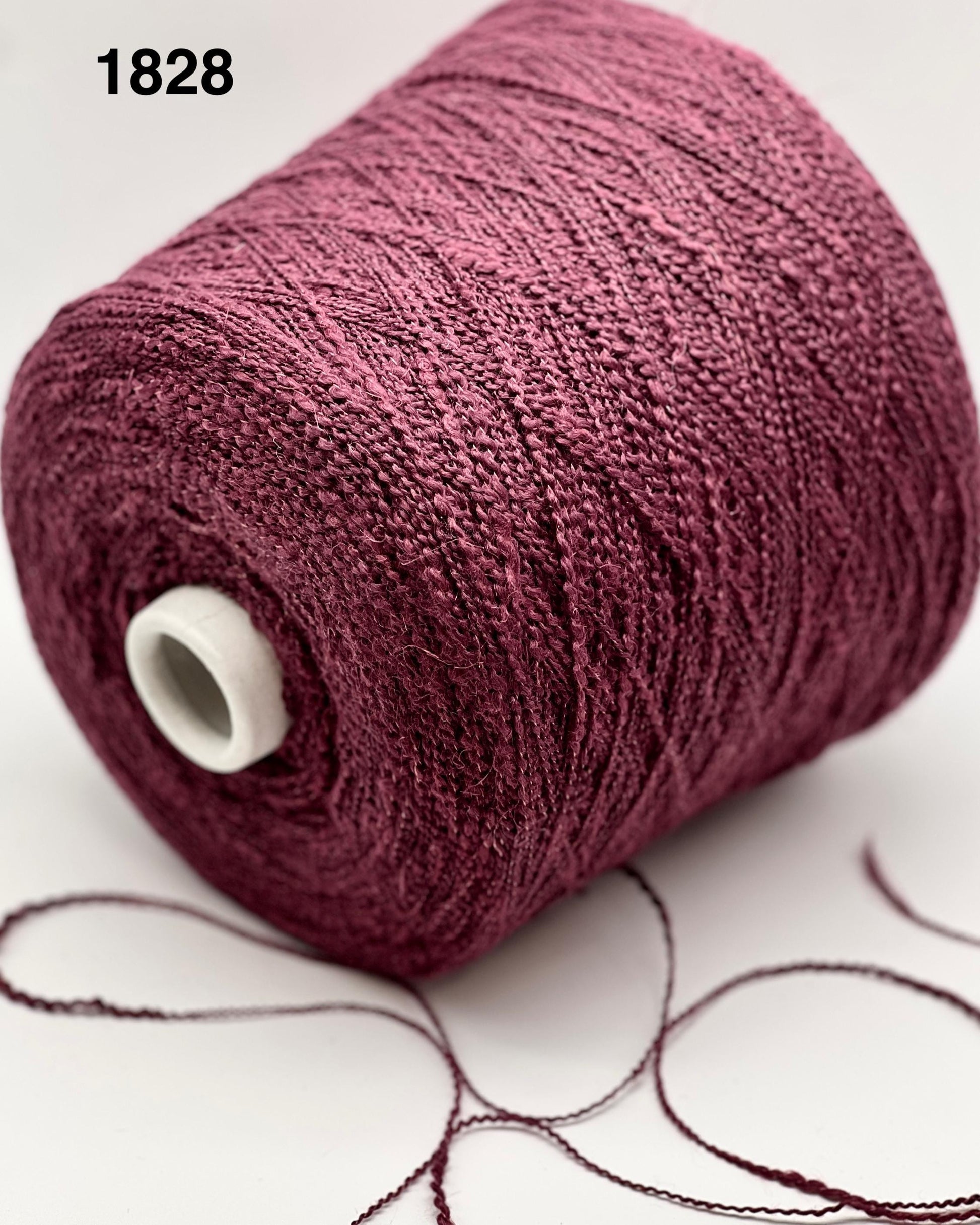 Spool of purple yarn on a white background