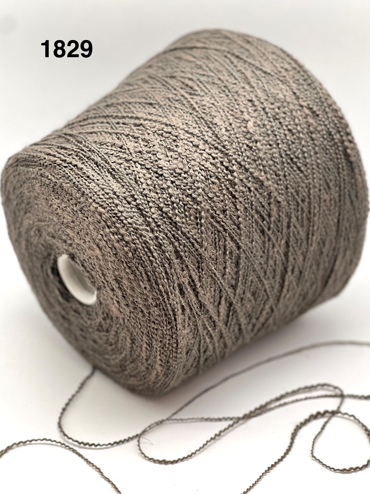 Spool of gray yarn on a white background