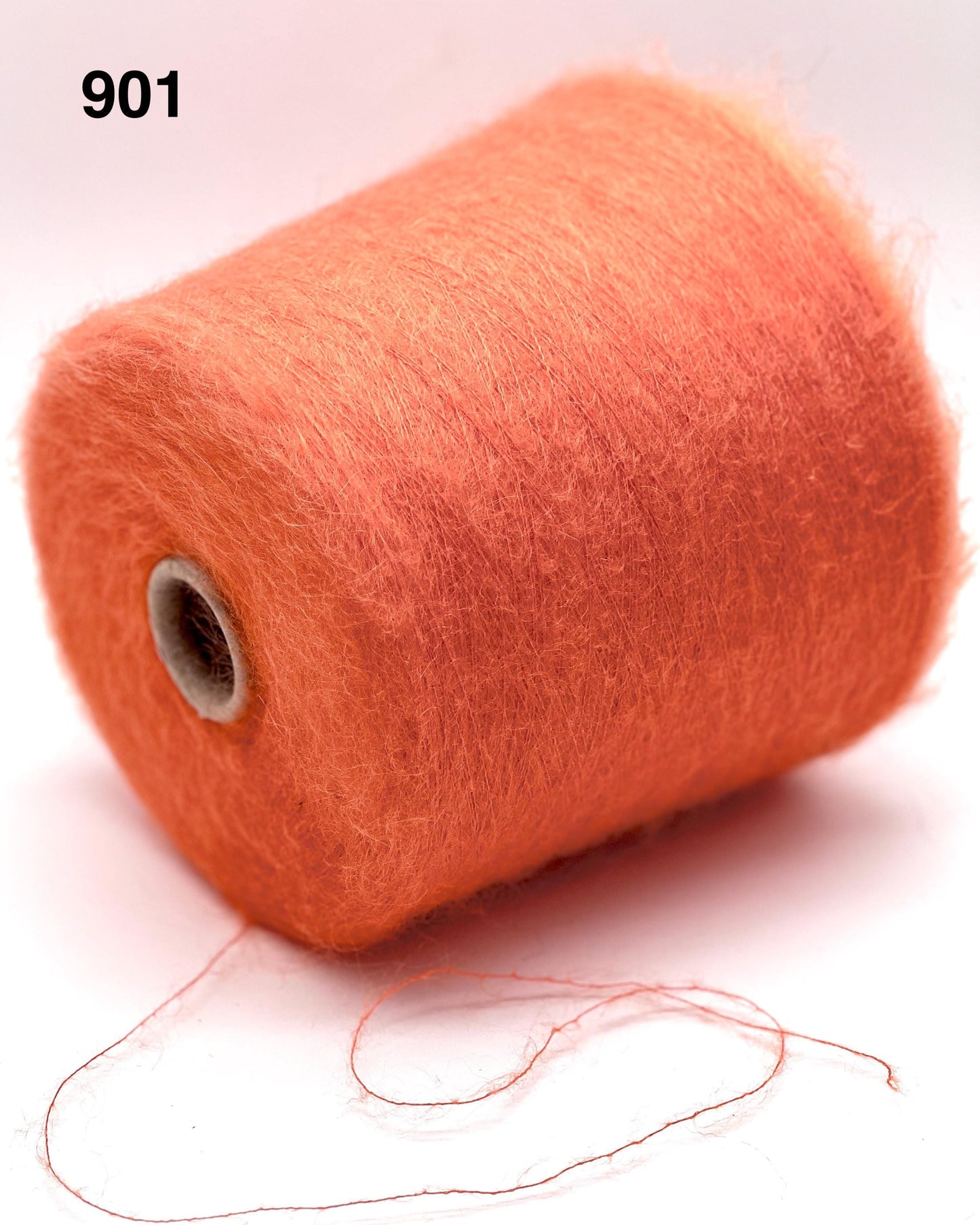 Spool of orange thread on a white background