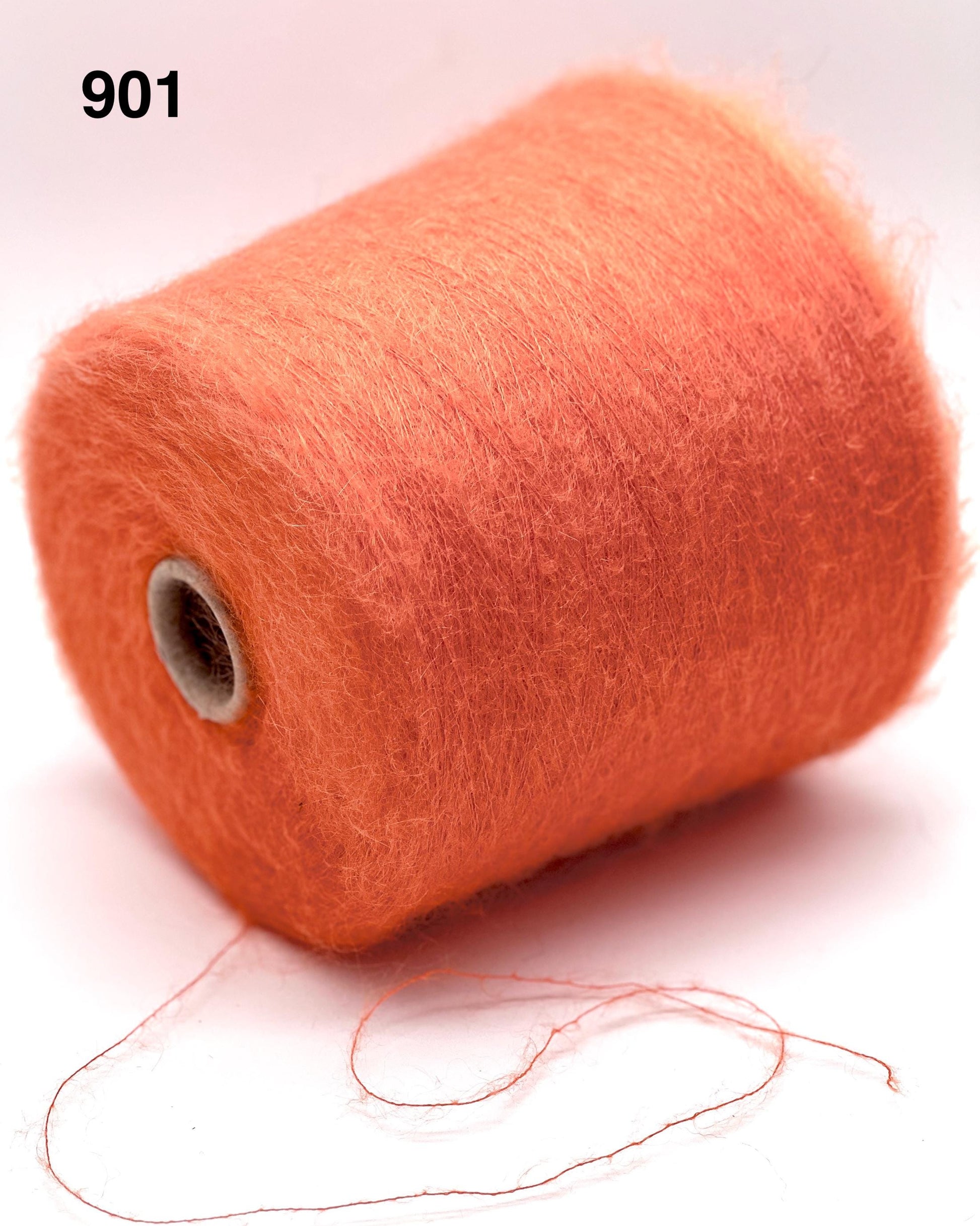 Spool of orange thread on a white background