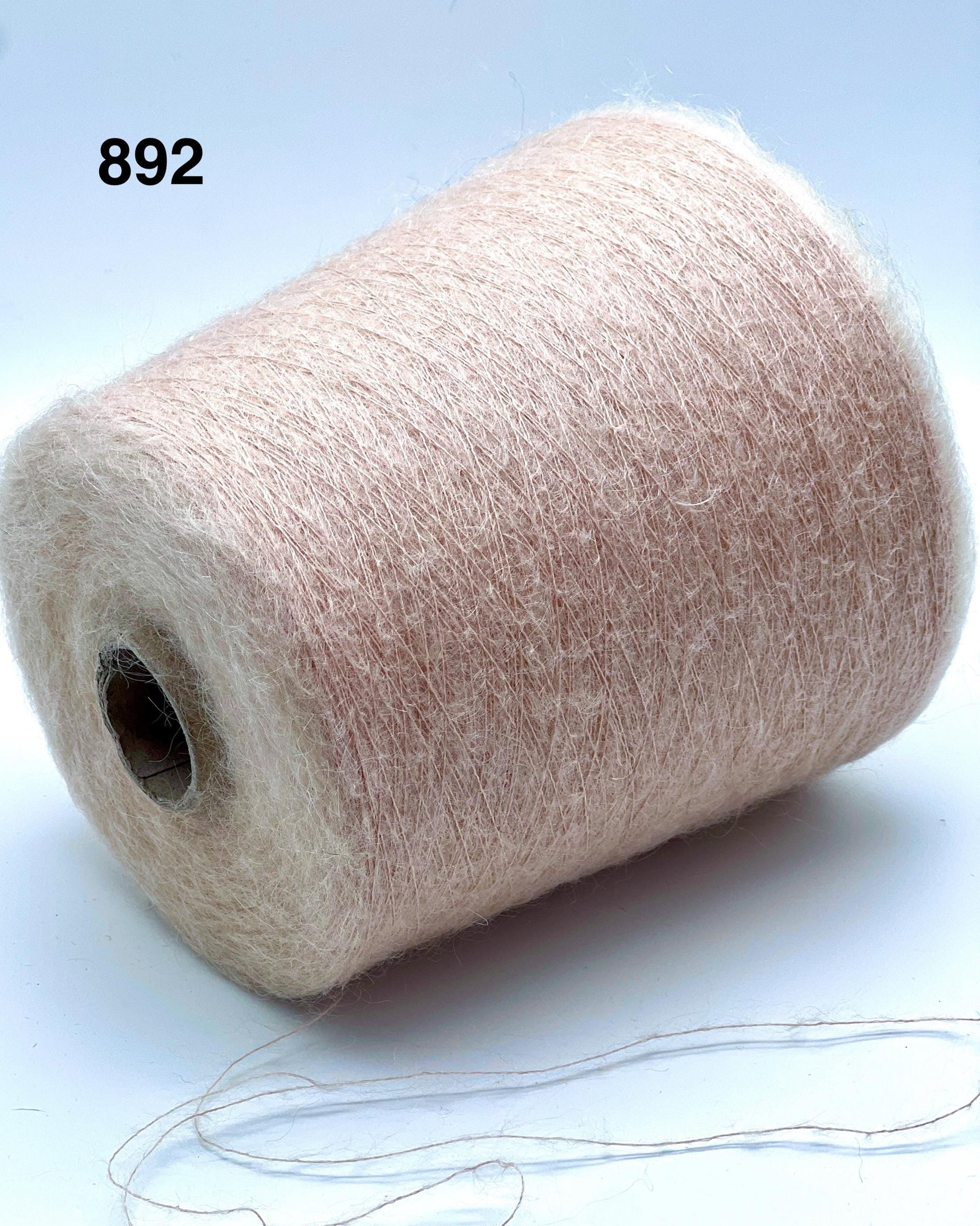 Spool of beige yarn on a white background